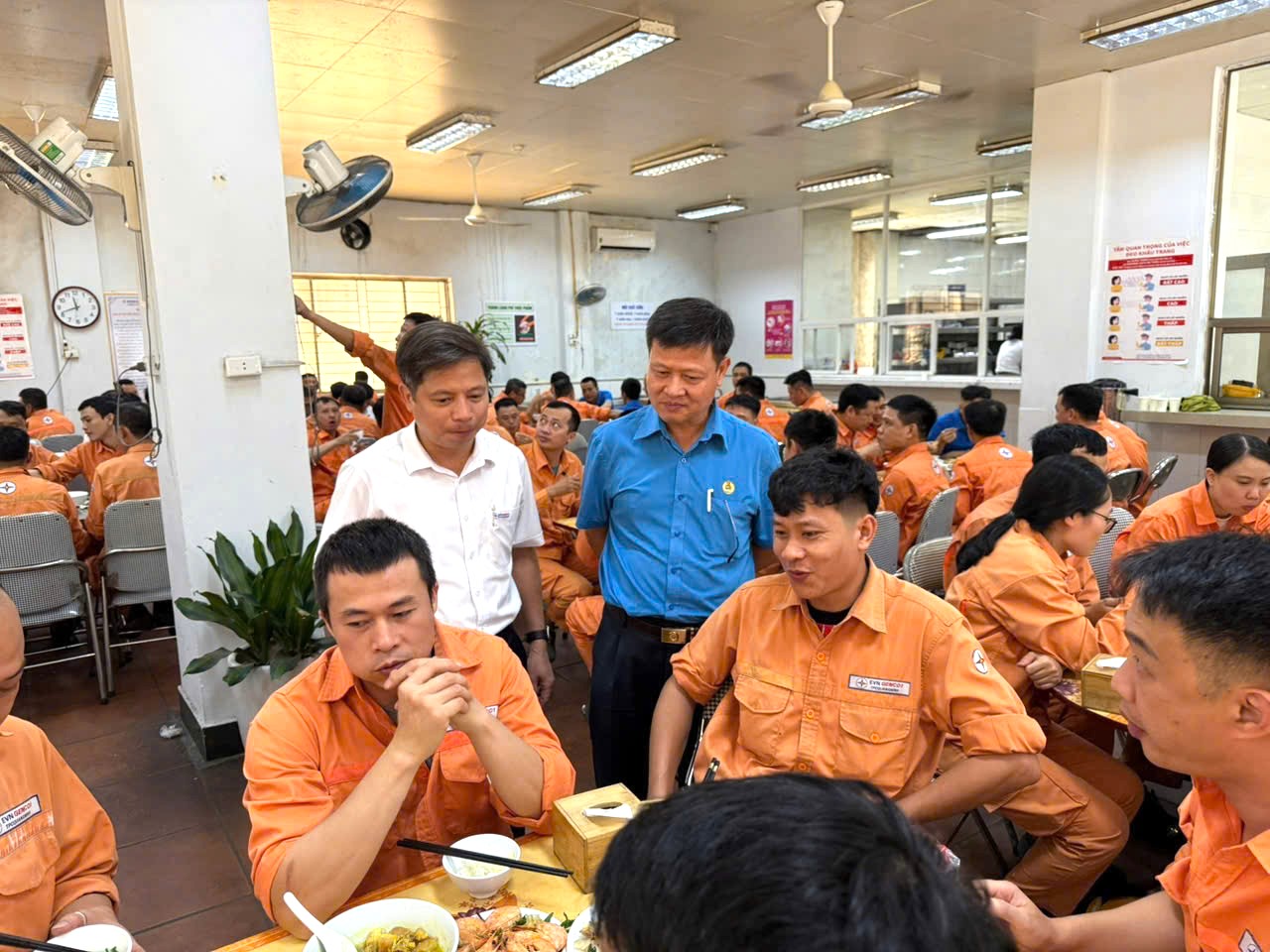 A group of people in orange shirts sitting at tablesAI-generated content may be incorrect.