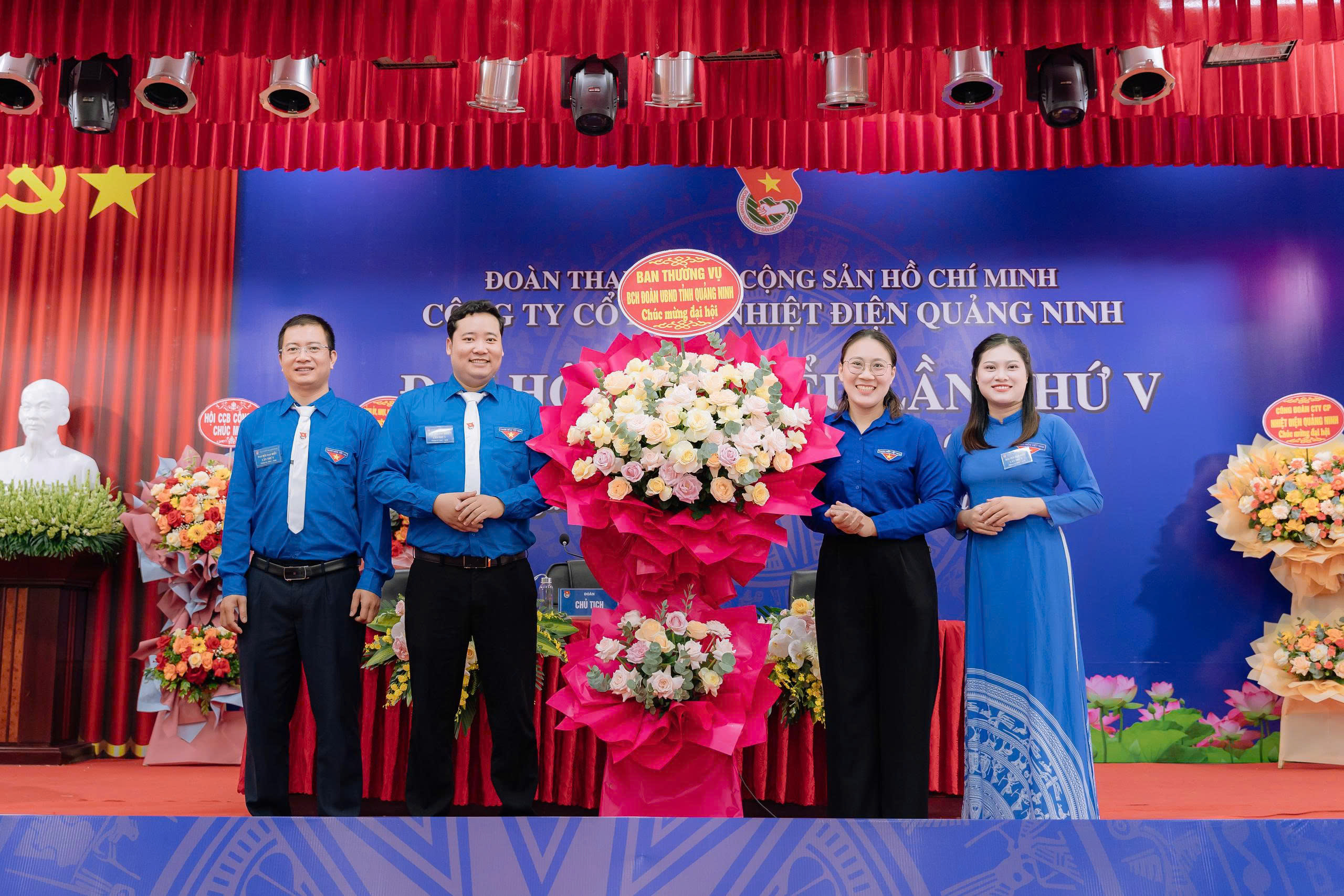 A group of people standing in front of a large bouquet of flowersAI-generated content may be incorrect.